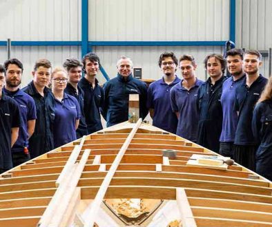 Berthon's new 2019-20 apprentices behind a boat being restored